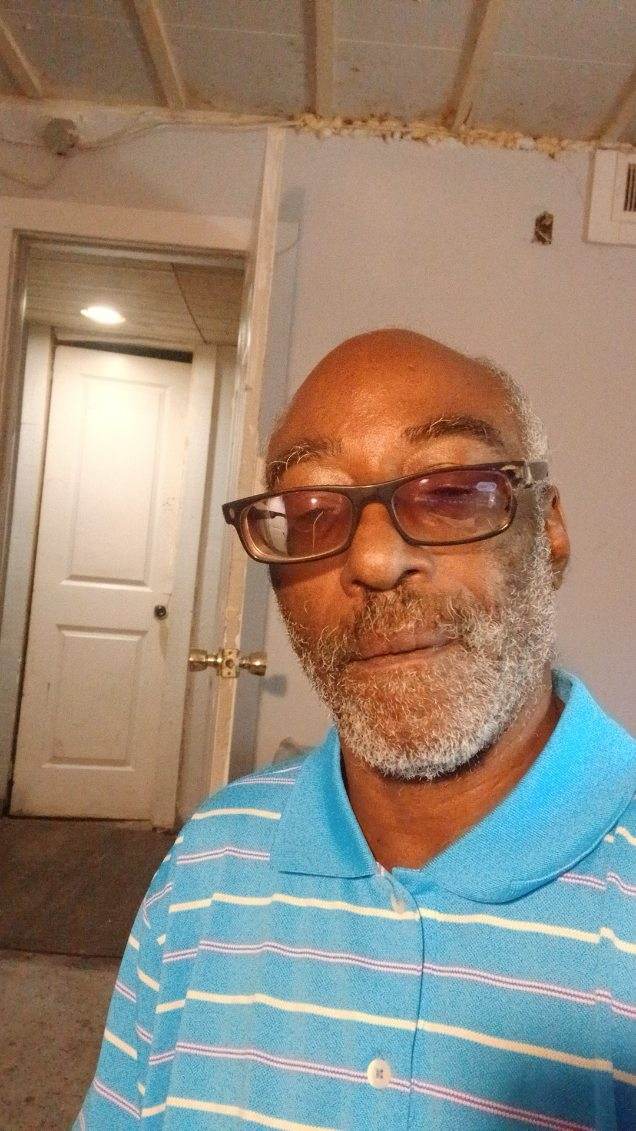 Emmett Lee White wearing a blue striped polo shirt, friendly selfie portrait